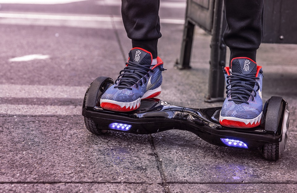 man with blue shoes using a black hoverboard